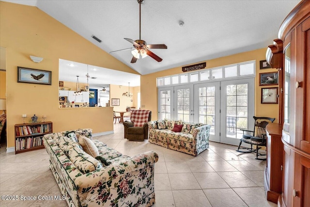 living room with ceiling fan, high vaulted ceiling, a textured ceiling, and light tile patterned floors