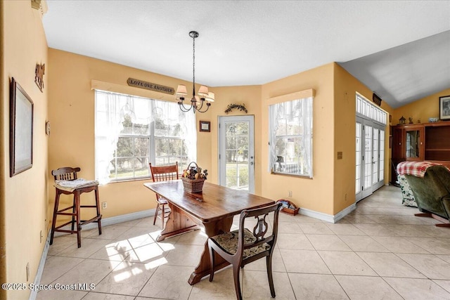 tiled dining space featuring lofted ceiling, a notable chandelier, french doors, and a healthy amount of sunlight