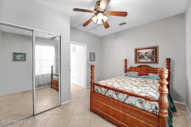 tiled bedroom with ceiling fan and a closet