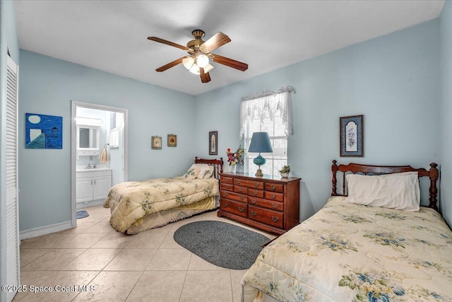 tiled bedroom featuring ceiling fan, ensuite bath, and a closet