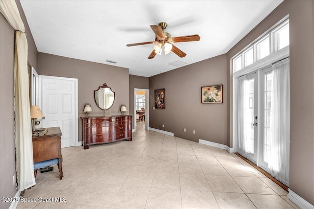 tiled entrance foyer featuring ceiling fan, french doors, and a healthy amount of sunlight