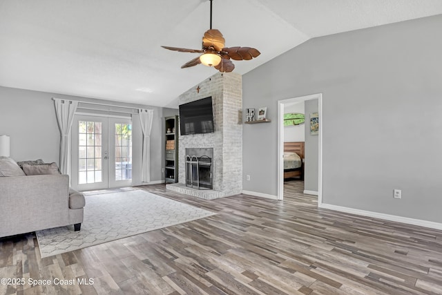 unfurnished living room featuring french doors, wood-type flooring, a fireplace, and vaulted ceiling