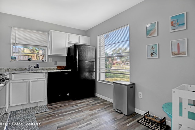 kitchen featuring white cabinetry, plenty of natural light, light hardwood / wood-style floors, and black appliances