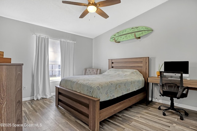 bedroom featuring ceiling fan, lofted ceiling, and light wood-type flooring