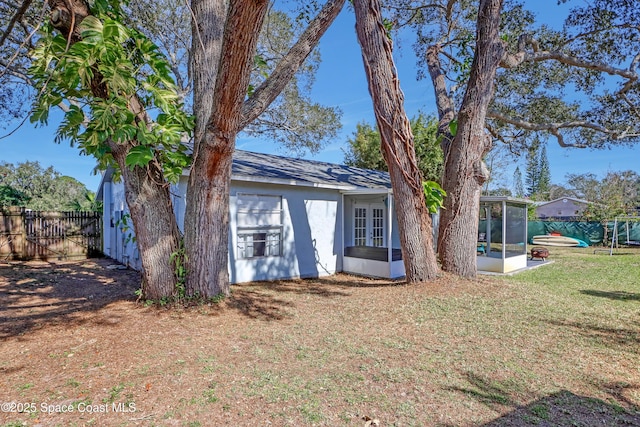 rear view of property with a yard and a sunroom