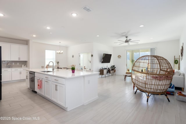 kitchen featuring sink, dishwasher, backsplash, an island with sink, and white cabinets