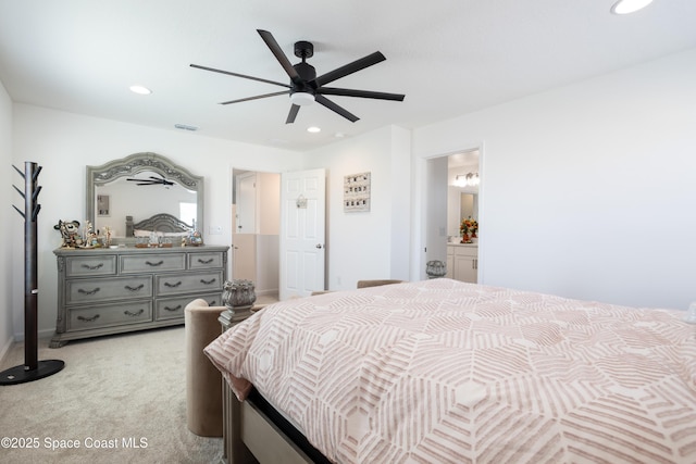 bedroom with ensuite bathroom, light carpet, and ceiling fan