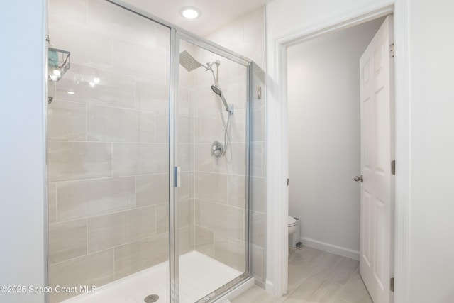 bathroom featuring walk in shower and toilet