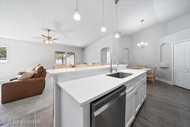 kitchen with pendant lighting, stainless steel dishwasher, a center island with sink, and white cabinets