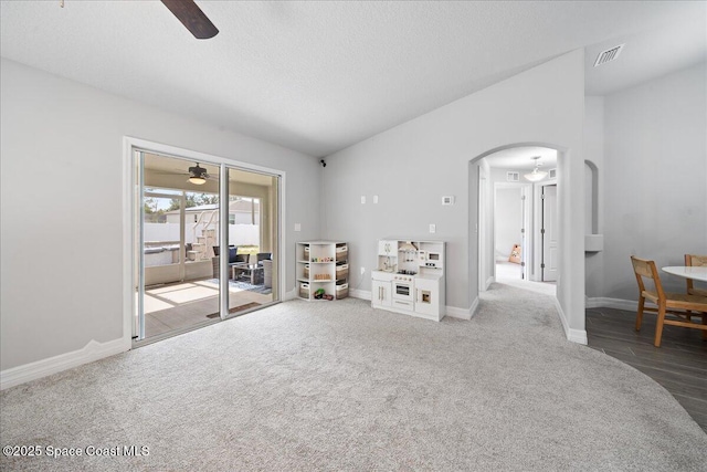 carpeted living room with lofted ceiling, a textured ceiling, and ceiling fan