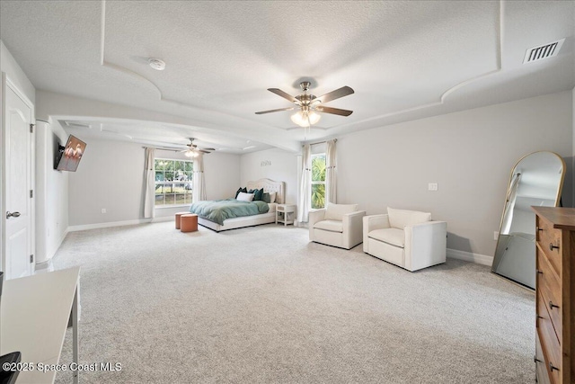 bedroom featuring ceiling fan, light carpet, and a textured ceiling