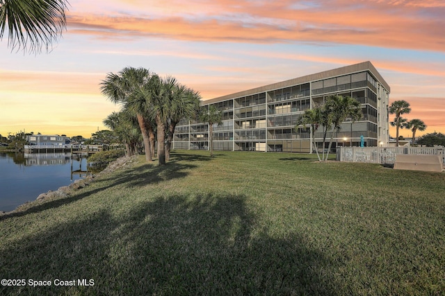 property at dusk featuring a water view