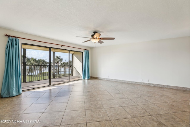 spare room featuring light tile patterned floors, ceiling fan, a textured ceiling, and a water view