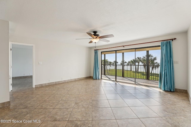 tiled empty room with a textured ceiling and ceiling fan