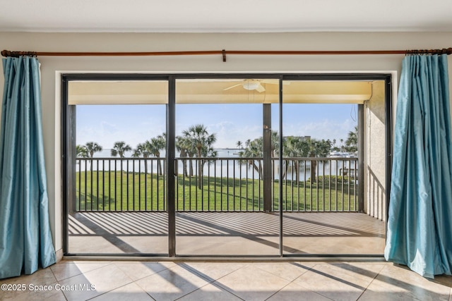 doorway with light tile patterned floors and a water view