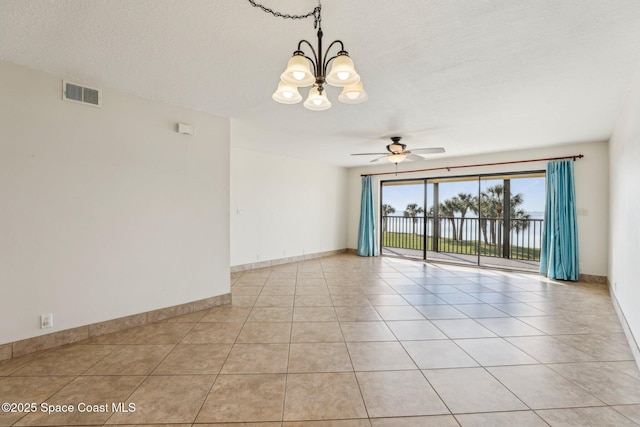 unfurnished room with light tile patterned floors, visible vents, ceiling fan with notable chandelier, and baseboards