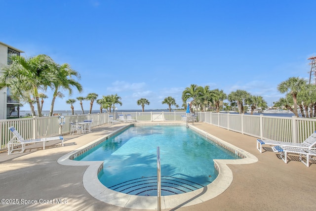 view of pool featuring a water view and a patio area