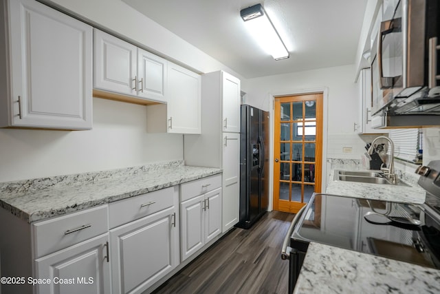 kitchen with dark hardwood / wood-style floors, electric range oven, white cabinetry, sink, and black fridge with ice dispenser