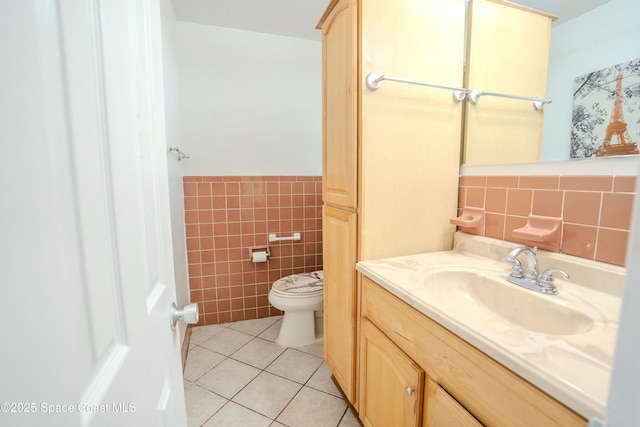 bathroom featuring tile patterned floors, toilet, tile walls, and vanity