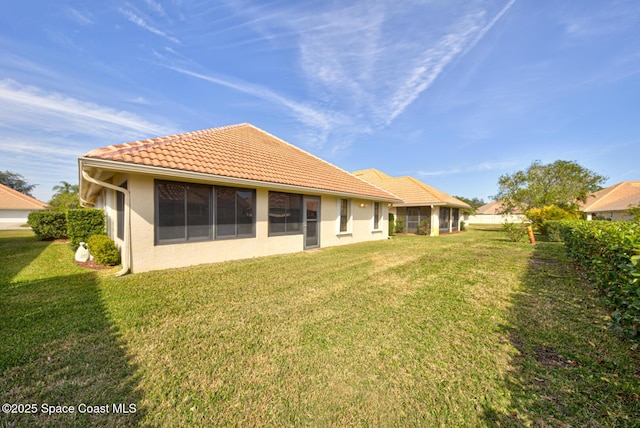 rear view of property featuring a lawn