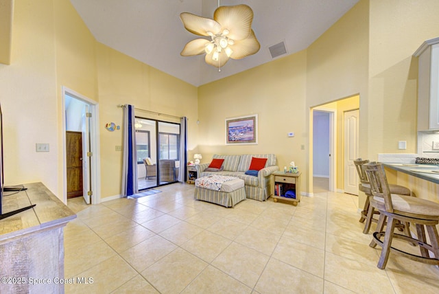 tiled living room with a high ceiling and ceiling fan