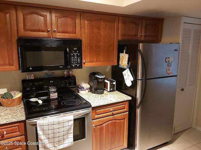 kitchen featuring light stone counters, appliances with stainless steel finishes, and light tile patterned floors