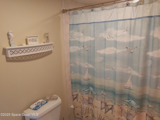 bathroom featuring curtained shower and toilet