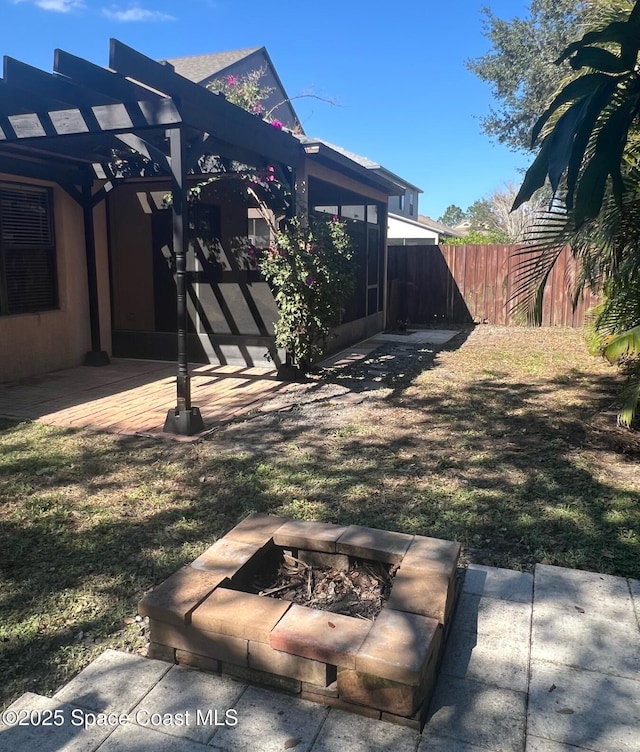 view of yard featuring a patio, fence, a pergola, and a fire pit