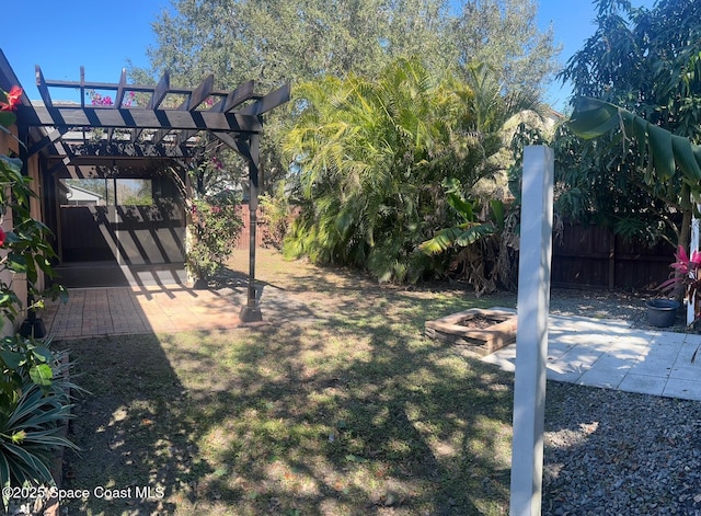 view of yard with an outdoor fire pit, a pergola, a patio, and fence