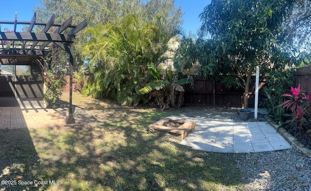 view of yard with a patio area, fence, a pergola, and an outdoor fire pit