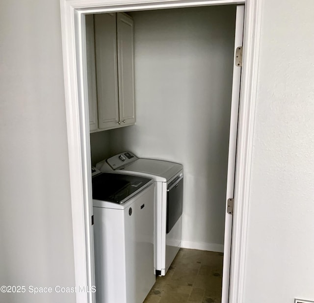 laundry room with cabinet space, separate washer and dryer, and baseboards