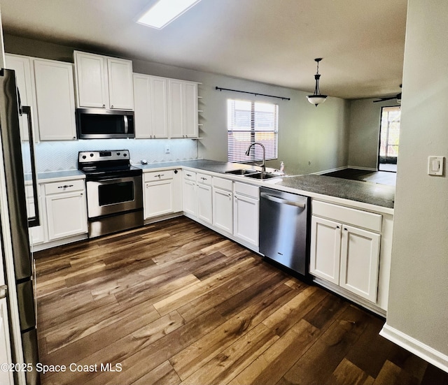 kitchen featuring dark wood-type flooring, a sink, open shelves, stainless steel appliances, and white cabinets