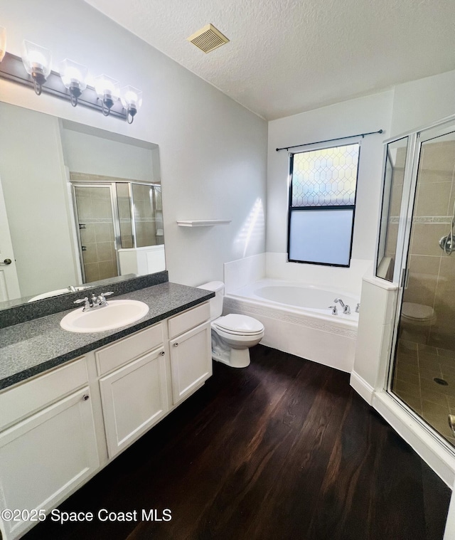 full bathroom with visible vents, a shower stall, wood finished floors, a bath, and a textured ceiling