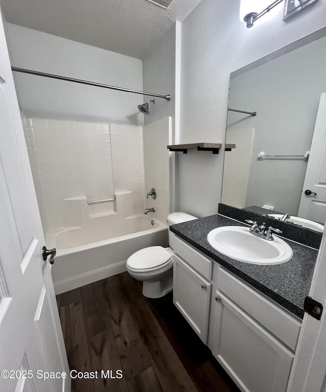 full bathroom with toilet, vanity, wood finished floors, a textured ceiling, and  shower combination