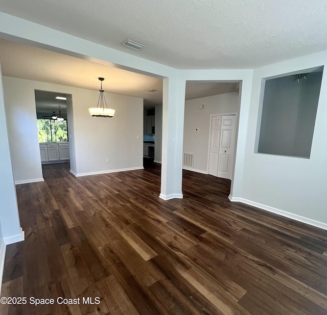 interior space with visible vents, baseboards, and dark wood-type flooring