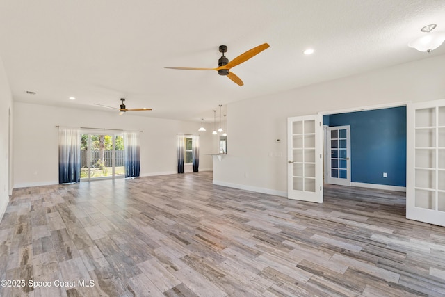 unfurnished living room with light hardwood / wood-style floors, french doors, and ceiling fan