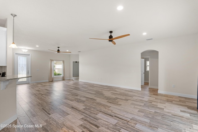 unfurnished living room with ceiling fan and light wood-type flooring