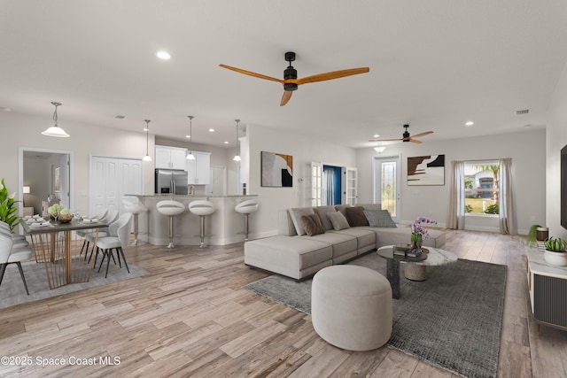 living room with ceiling fan and light hardwood / wood-style floors