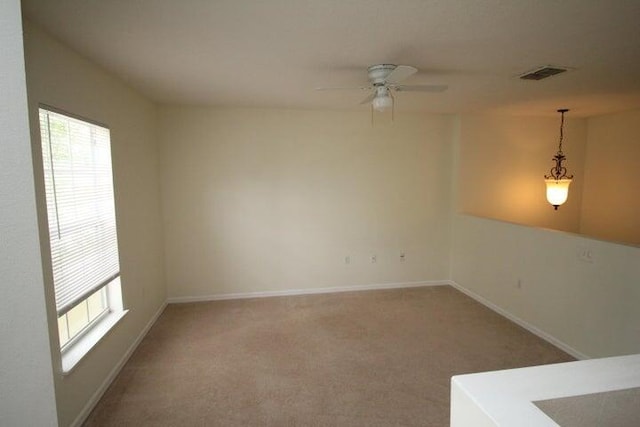 carpeted spare room with ceiling fan