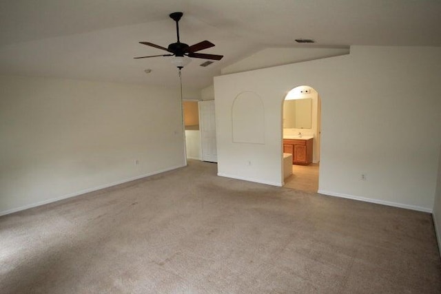 spare room featuring vaulted ceiling, light colored carpet, and ceiling fan