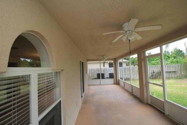 unfurnished sunroom with ceiling fan