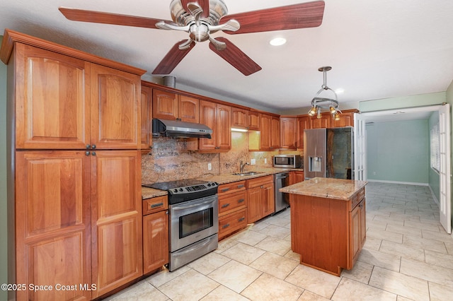 kitchen featuring a kitchen island, tasteful backsplash, sink, light stone counters, and stainless steel appliances