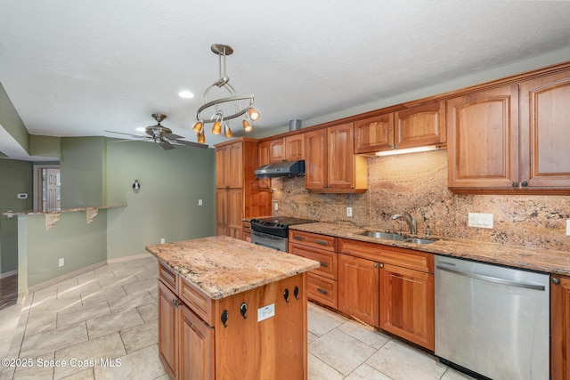 kitchen featuring sink, appliances with stainless steel finishes, hanging light fixtures, backsplash, and a center island