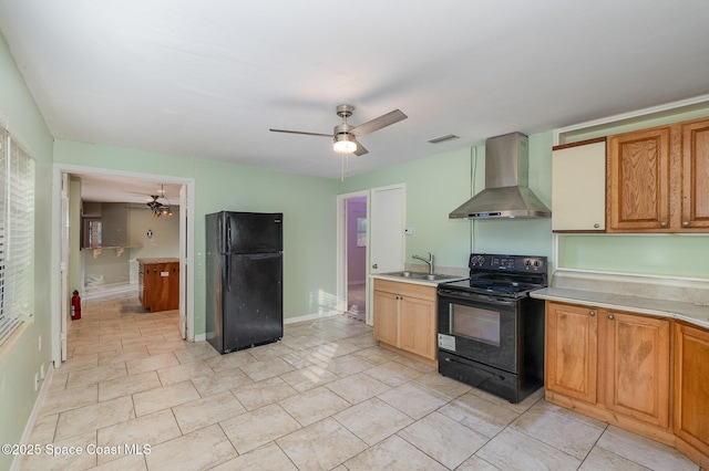 kitchen featuring ceiling fan, black appliances, sink, and wall chimney range hood