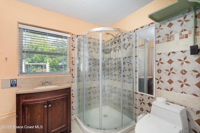 bathroom featuring toilet, tile walls, vanity, and walk in shower