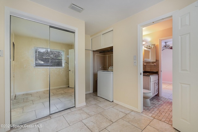 interior space featuring washer / clothes dryer, light tile patterned floors, and a closet