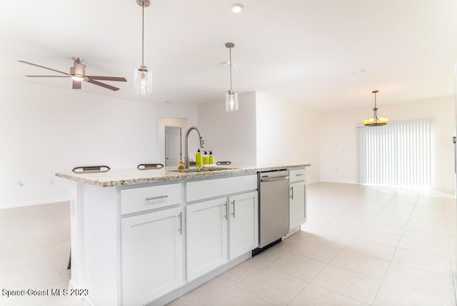 kitchen with stainless steel dishwasher, decorative light fixtures, sink, and a center island with sink