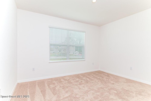 spare room featuring light colored carpet