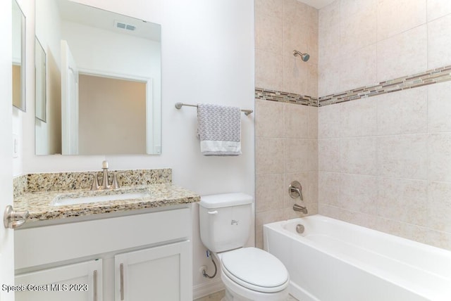 full bathroom featuring tiled shower / bath combo, vanity, and toilet