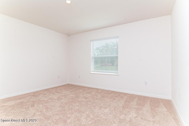 unfurnished room featuring light colored carpet